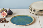 pottery cake plate with blue and green glazing and figs and chocolate on the background