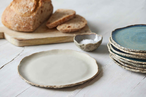 rustic pottery side plate with bread on background