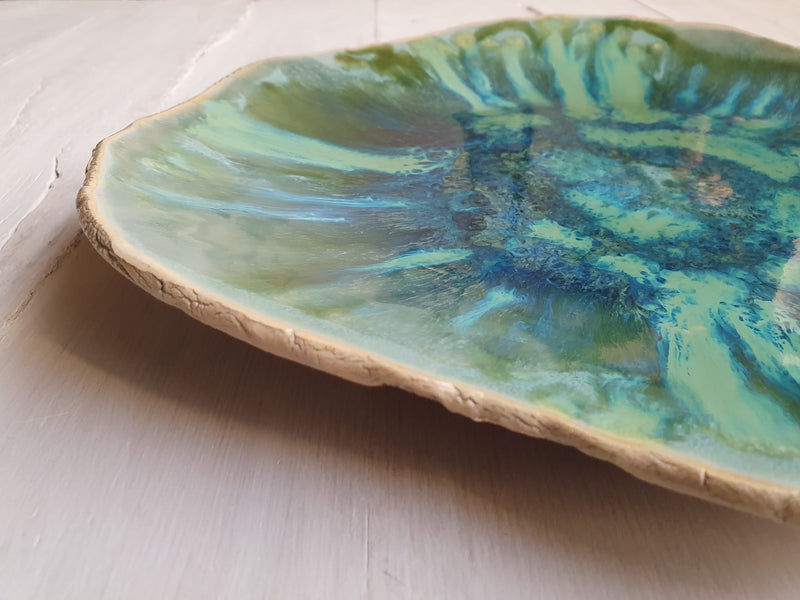 Decorative plate with a natural edge and green and blue abstract design