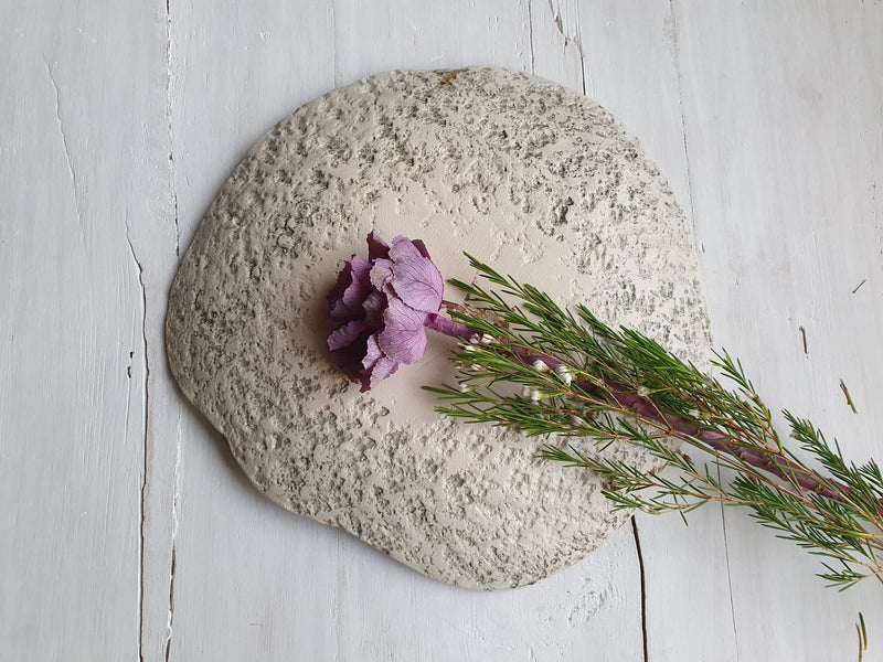 Back side of ceramic art piece shaped like a stone